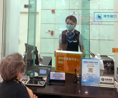 建行成都金河支行，柜面員工使用“關愛服務卡”服務老年客戶